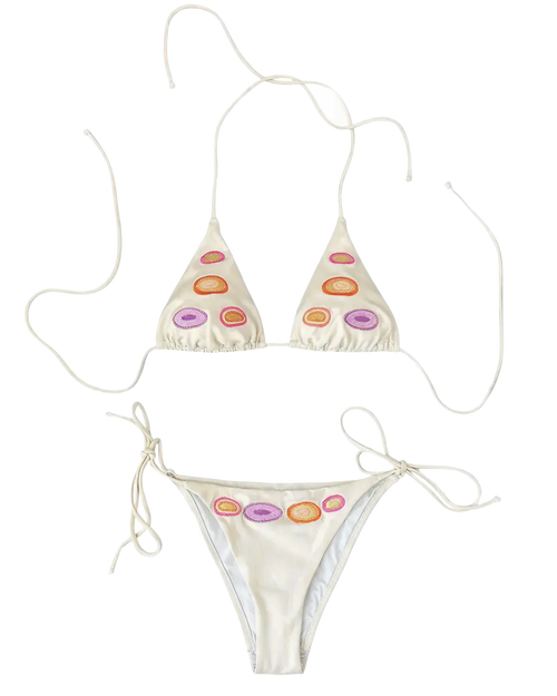 An off-white string bikini set with colorful dots motif embroidery on the front of the triangle top and the waistband of the tie-side bottoms, displayed on a solid white background.